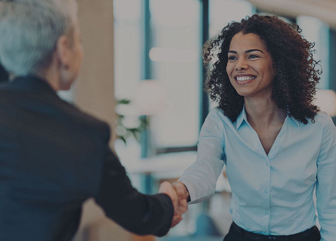 Smiling banker shakes hands with customer